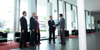 Colaborador e cliente apertando as mãos no lobby