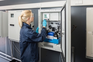 Técnicos de serviço realizam atividades de manutenção em um analisador de líquidos