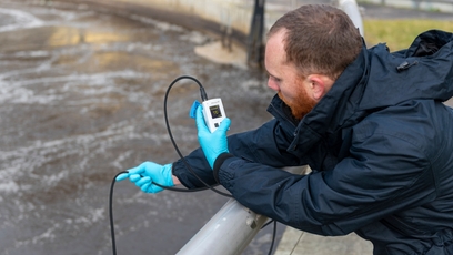 Homem verifica um ponto de medição de OD com um medidor de oxigênio portátil